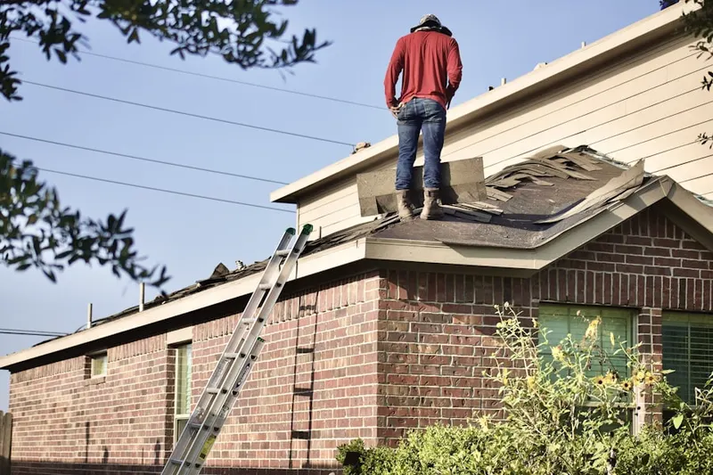 Professional roofer working on a residential roof in Economy